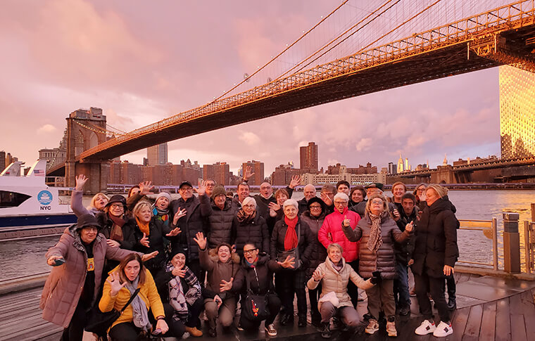 tour group in front of the Brooklyn bridge at sunset